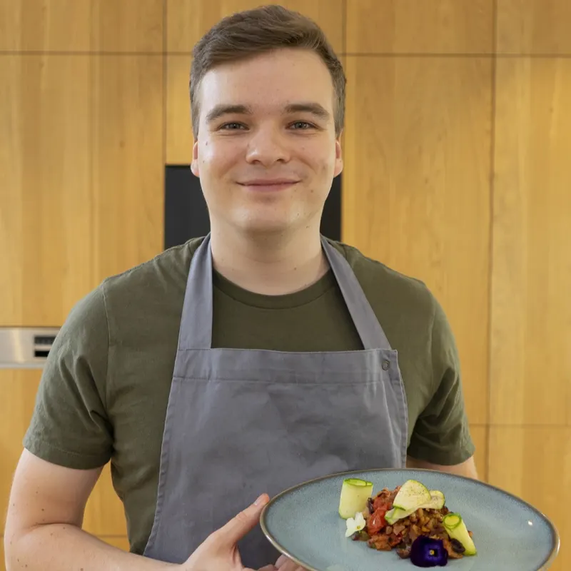 Benedikt Weinheimer hält einen Teller mit neu interpretierter Panzanella