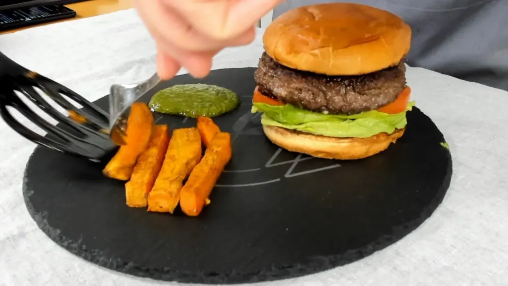 Italienischer Burger mit Salsiccia und Süßkartoffelpommes auf Schieferplatte
